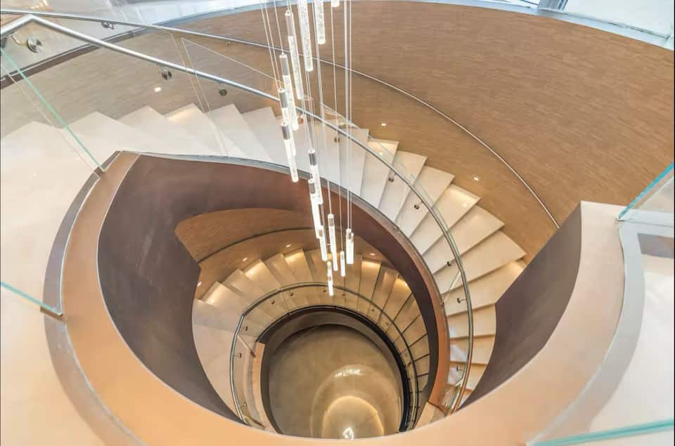The resort's grand spiral staircase beneath a cascade of pendant lights