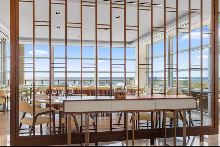 A dining room framed by a slatted wood screen