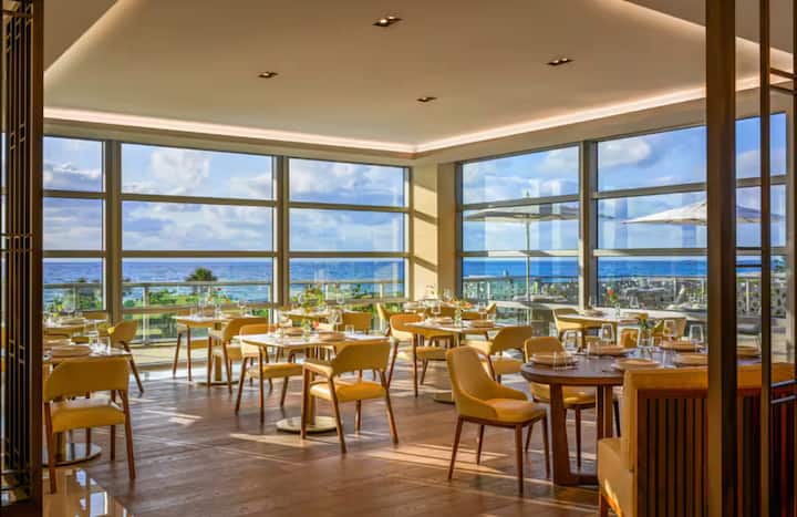 A resort restaurant dining room with ocean views at golden hour