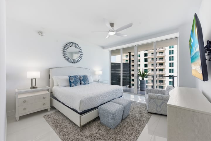 A bright bedroom with ocean views through the glass