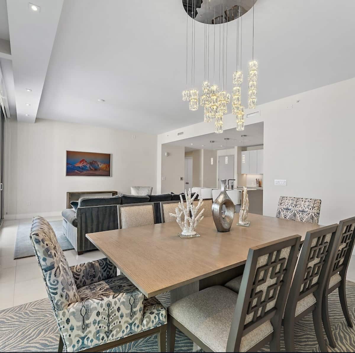 The dining table beneath a cascading crystal pendant chandelier