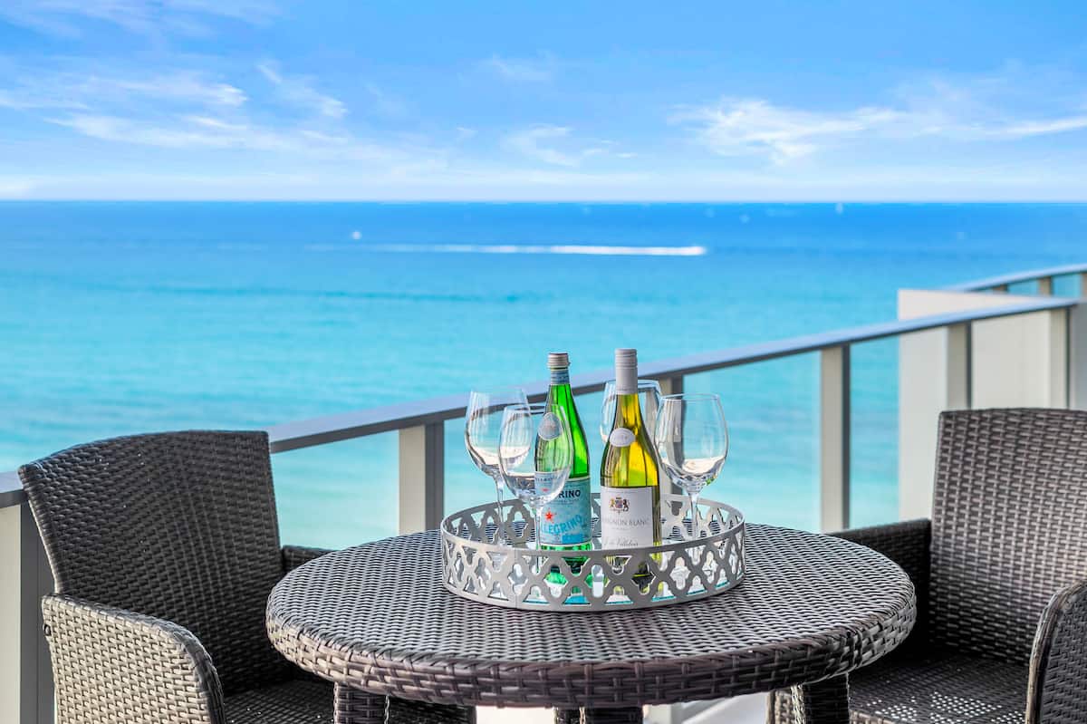 A balcony table set with glasses, the Atlantic filling the view behind
