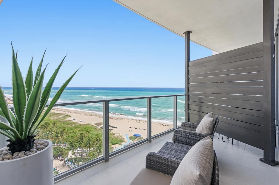 A balcony with an aloe planter overlooking the beach