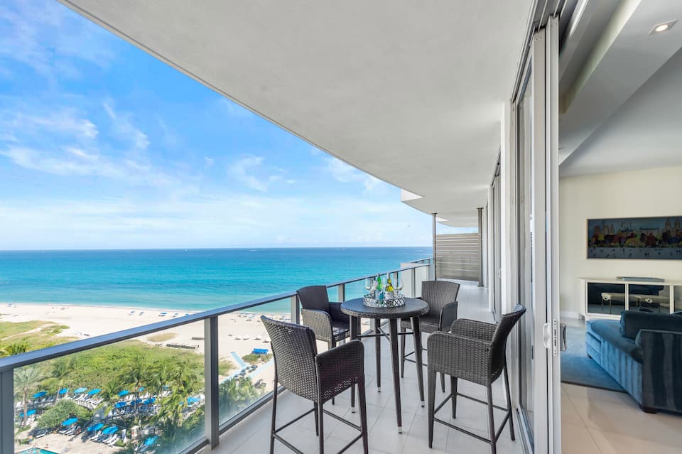 The long curved balcony with wicker lounge chairs above the beach