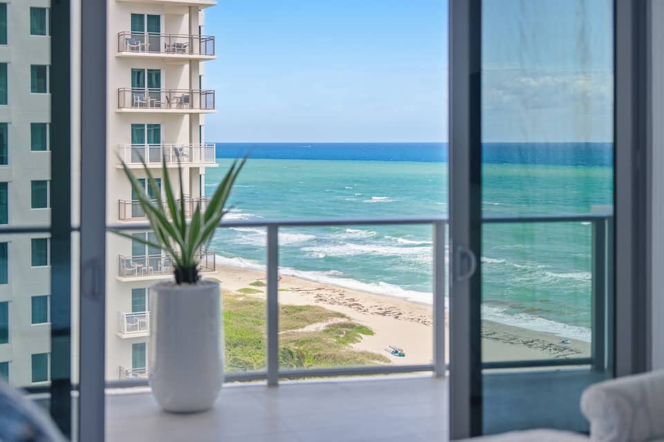 A balcony with a planter, looking out over the beach