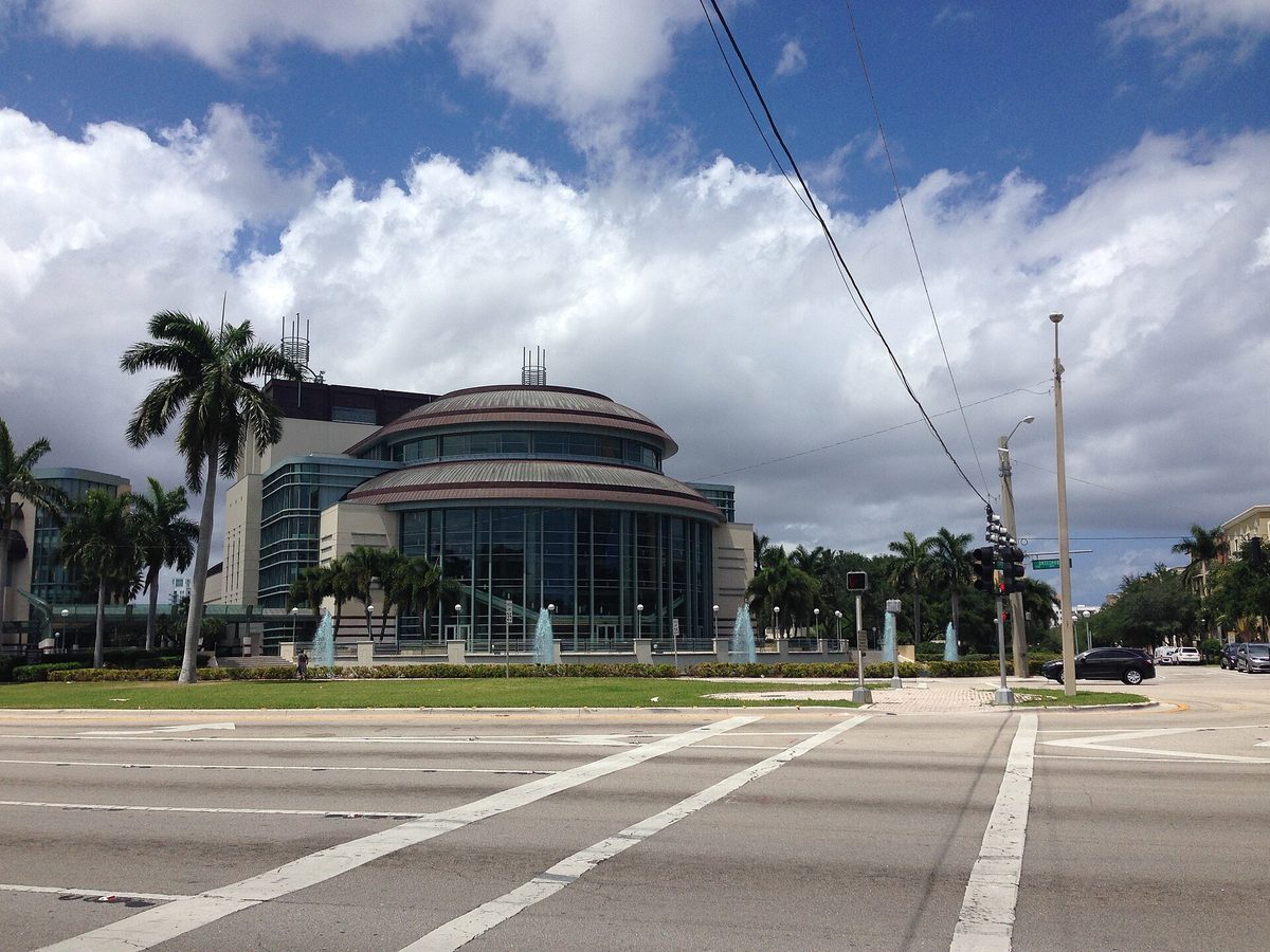 The round glass front of the Kravis Center for the Performing Arts with palms and fountains, West Palm Beach