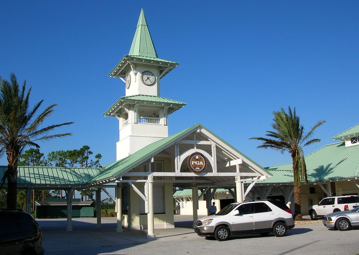 The clock tower and entrance of the PGA Village golf club in Port St. Lucie, Florida, under a blue sky